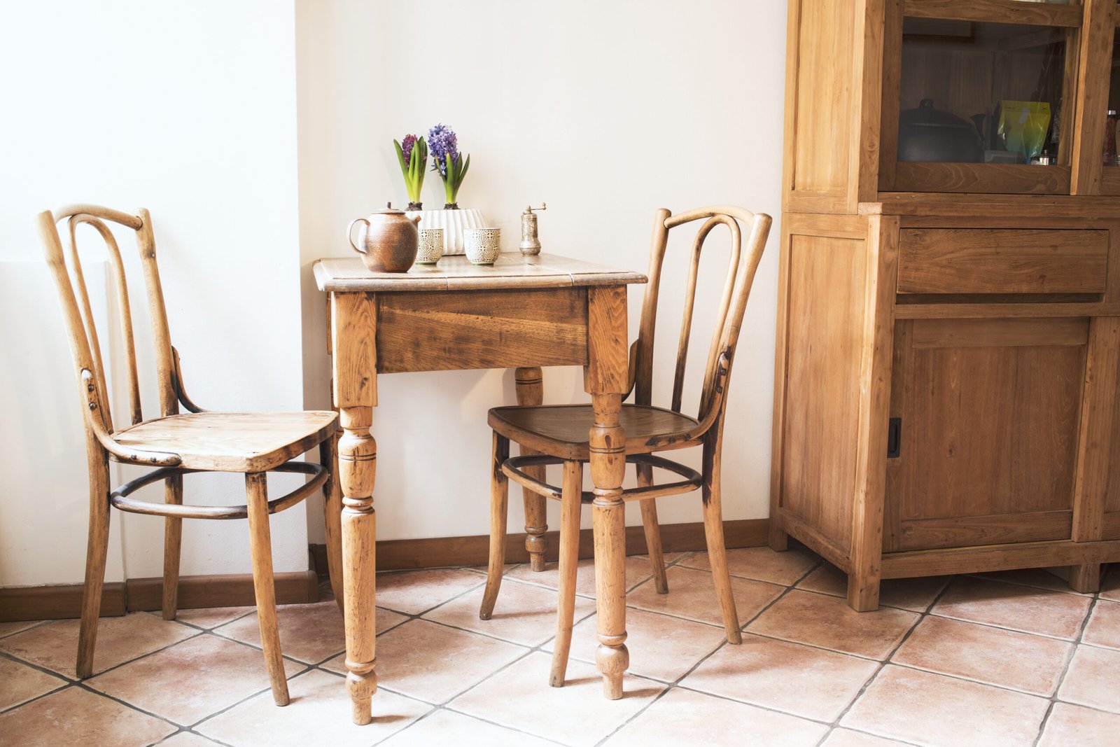 Zwei alte Holzstühle mit geschwungenen Lehnen an einem kleinen Holztisch